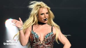 Britney Spears performing on stage wearing a bejeweled outfit and headset microphone