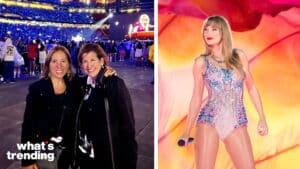 Two women smiling at a concert with a large crowd and Taylor Swift performing on stage in the background
