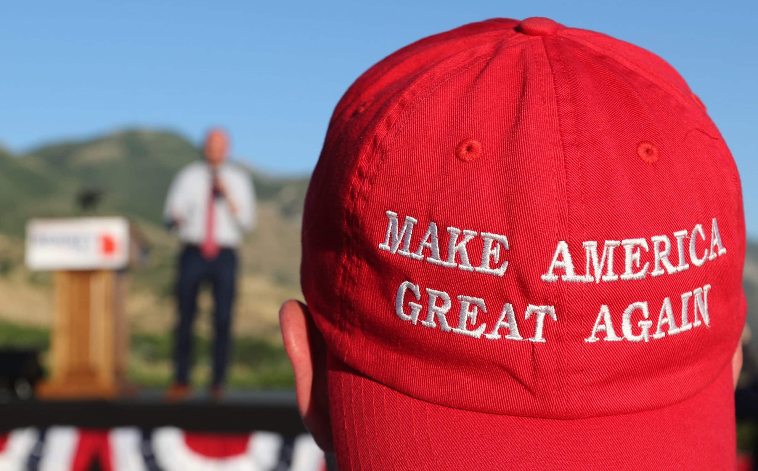 OREM, UT - JUNE 26: A Romney supporter listens to a speaker as he wears a "Make America Great Again" hat at the Mitt Romney election party on June 26, 2018 in Orem, Utah. It is primary election day in Utah and Romney is running for the Utah U.S. Senate seat of Senator Orin Hatch who is retiring. 