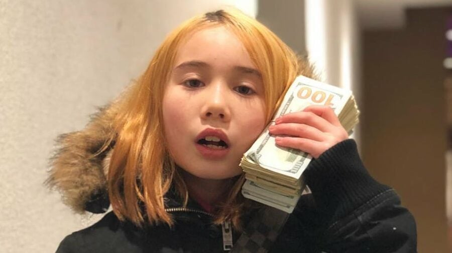 Rapper Lil Tay poses with a large handful of cash.