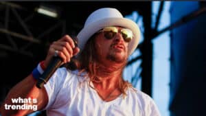 Male singer wearing a white hat and sunglasses performing on stage with a microphone and "what's trending" logo.