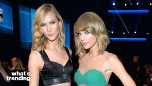 Karlie Kloss and Taylor Swift posing together at an event with stage lights in the background