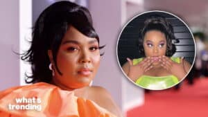 Lizzo in an orange off-shoulder dress and a green shiny top with surprised expression and hands near mouth.