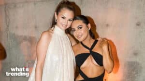 Selena Gomez and Demi Lovato posing together, Selena in a white dress and Demi in a black cut-out outfit.