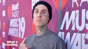 Travis Barker wearing a black beanie and gray shirt at the 2019 iHeartRadio Music Awards red carpet