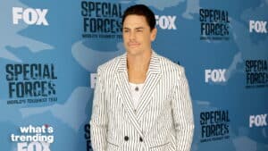 Man in a white pinstripe suit posing at FOX Special Forces World's Toughest Test event backdrop