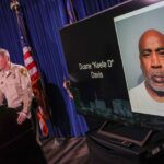 LAS VEGAS, NEVADA - SEPTEMBER 29: A booking photo of Duane "Keefe D" Davis is shown on a television monitor as Clark County Sheriff Kevin McMahill (L) and Las Vegas Metropolitan Police Department Lt. Jason Johansson speak during a news conference at the LVMPD headquarters to brief media members on Davis' arrest and indictment for the 1996 murder of Tupac Shakur on September 29, 2023 in Las Vegas, Nevada. A Nevada grand jury indicted Davis on one count of murder with a deadly weapon in the fatal drive-by shooting of rapper Tupac Shakur.