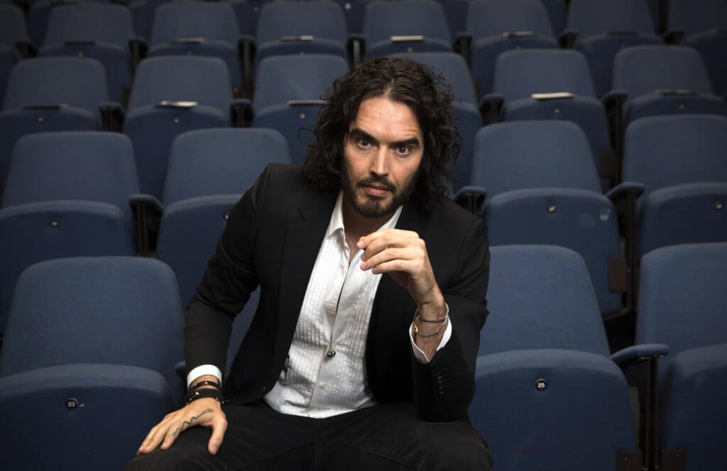 Russell Brand poses for photographs as he arrives to deliver The Reading Agency Lecture at The Institute of Education on November 25, 2014 in London, England. Russell Brand will deliver 'a manifesto on reading' which will be in part personal, sharing his own experience of books and reading while growing up in the UK.