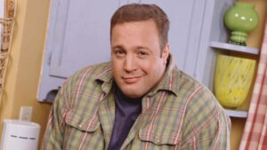 Promotional portrait of American actor and comedian Kevin James in costume as the charcter Doug Heffernan as he poses with his hands in his pockets on the set of the television sitcom 'The King of Queens,' late 1990s.