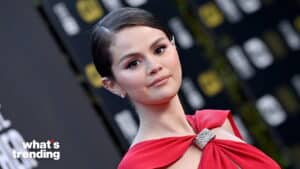 Selena Gomez wearing a red dress at a formal event with a "what's trending" logo in the corner