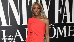 Woman with long blonde braids wearing a red one-shoulder dress at a Lancome event backdrop