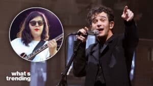 Musician Matty Healy singing on stage with an inset of a woman playing guitar wearing sunglasses and a white shirt