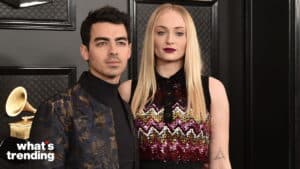 Joe Jonas and Sophie Turner posing at the Grammy Awards with a golden gramophone trophy in the background
