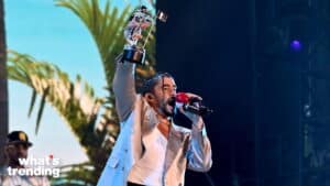 Musician Bad Bunny holding a MTV Video Music Award trophy and singing into a microphone on stage