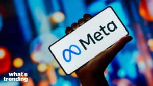 Hand holding smartphone displaying the Meta logo on a blurred colorful background