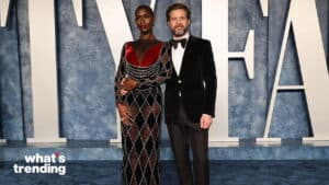 Adut Akech and Joshua Jackson posing on the red carpet in formal attire at a Vanity Fair event