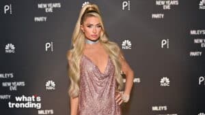 Paris Hilton in a sparkling pink dress and silver choker at Miley's New Year's Eve Party backdrop