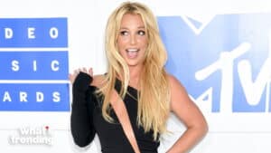 Britney Spears smiling and waving in a black dress at the MTV Video Music Awards.