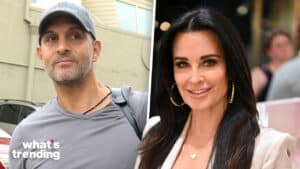 Kyle Richards smiling in a white blazer and a man wearing a gray shirt and cap outdoors