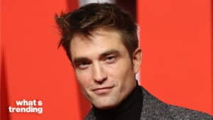 Robert Pattinson wearing a gray coat and black turtleneck against a red background with "what's trending" text