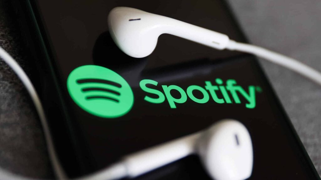 Spotify logo displayed on a phone screen and headphones are seen in this illustration photo taken in Krakow, Poland on July 12, 2022.
