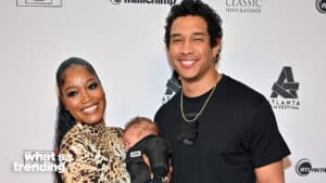 Keke Palmer and Darius Jackson smiling at Atlanta Film Festival event, Palmer holding their sleeping baby.