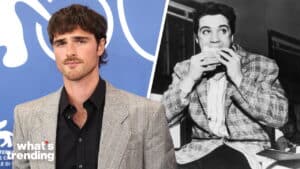 Young man in gray blazer and black shirt next to black-and-white photo of Elvis Presley eating a sandwich