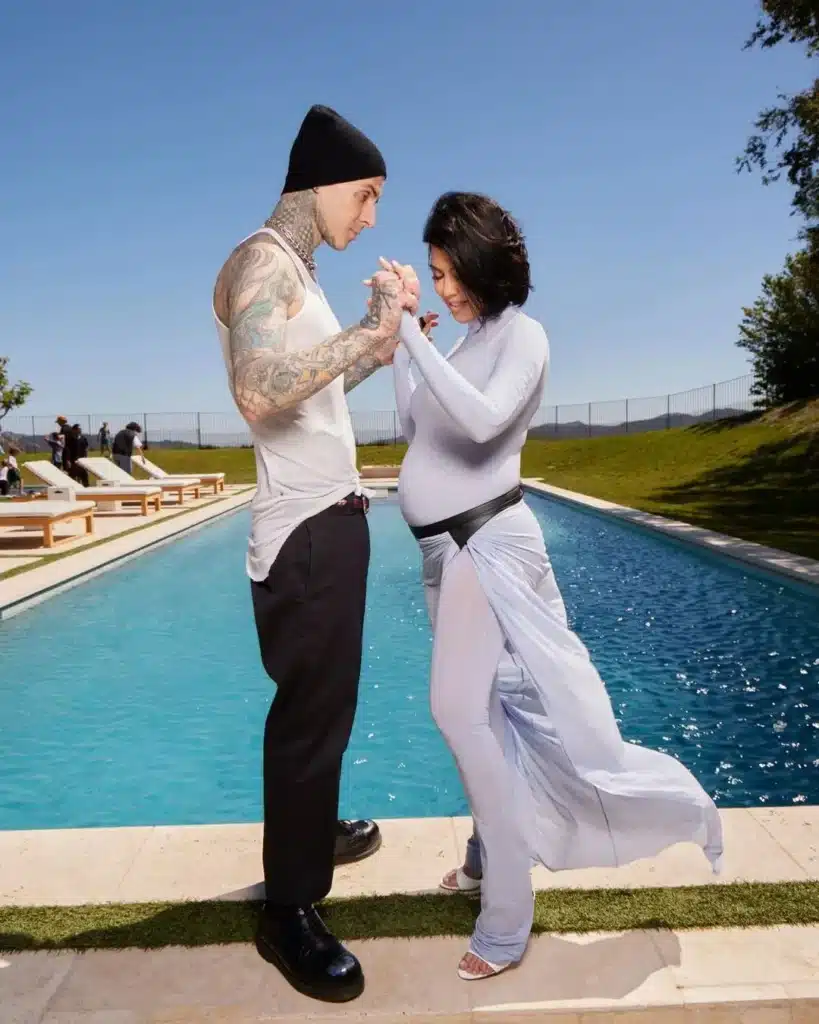 Kourtney Kardashian and Travis Barker pictured via Instagram overlooking a pool. 