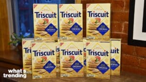 Stack of Triscuit Original crackers boxes on a wooden surface with a brick wall background