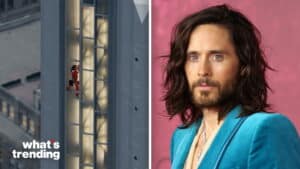 Jared Leto in a teal suit jacket with long hair and beard next to a person climbing a tall building facade at night