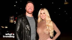 Man in black leather jacket and woman in sheer brown top posing together at night