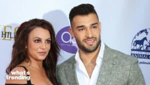 Britney Spears and Sam Asghari posing together at a daytime beauty event with animal charity logos in the background
