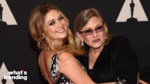 Billie Lourd and Carrie Fisher posing together at an event with Oscar statuette silhouettes in the background