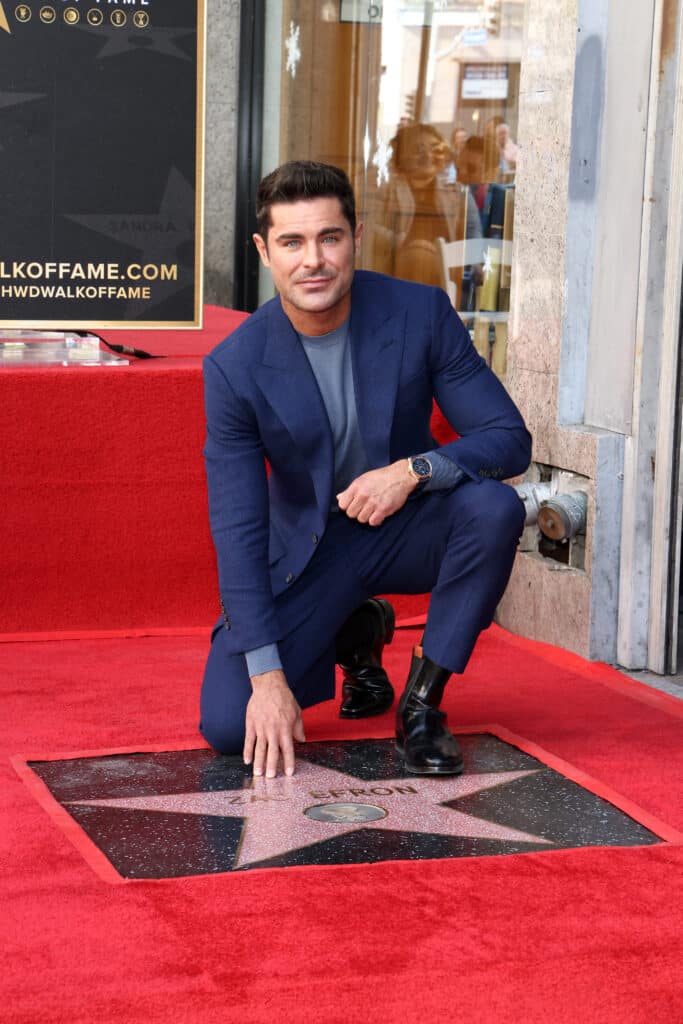 US actor Zac Efron poses by his newly unveiled star during his Hollywood Walk of Fame ceremony in Hollywood, California, December 11, 2023.