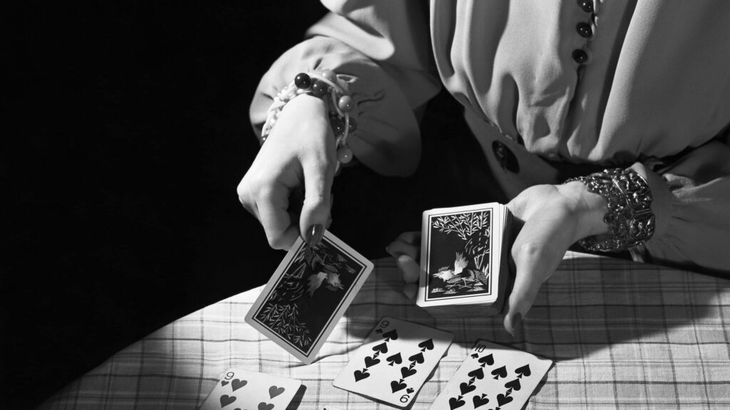 A fortuneteller lays out playing cards to predict her customer's future.