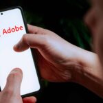 In this photo illustration an Adobe logo seen displayed on a smartphone.