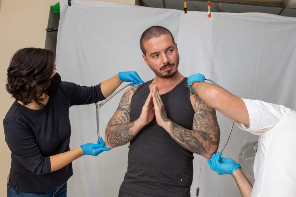 J Balvin posing for the creation of his wax figure.