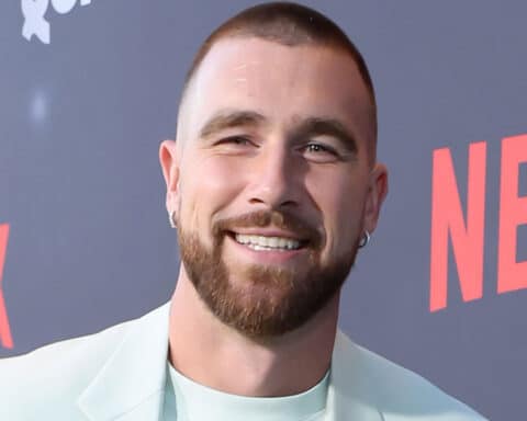 Man with beard and earrings smiling at Netflix event backdrop