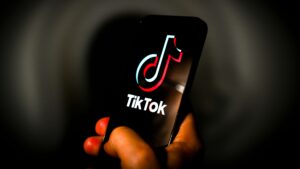 The TikTok logo is seen on a mobile device screen in this illustration