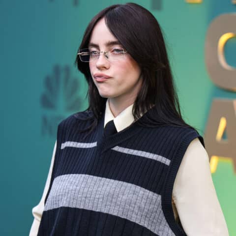 Billie Eilish wearing glasses and a black and gray sweater vest at the Critics Choice Awards
