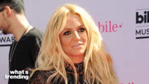 Britney Spears with long blonde hair and black lace outfit at a music awards event with T-Mobile branding visible