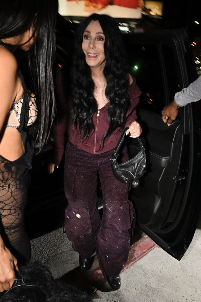 Cher avoids a near fall as she exits her vehicle as she attends a Halloween party at Chateau Marmont.