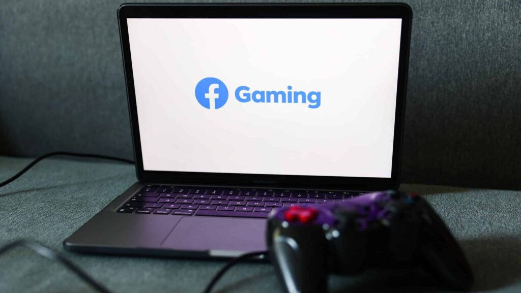 Facebook Gaming logo displayed on a laptop screen and a gamepad are seen in this illustration photo taken in Krakow, Poland on August 23, 2022.