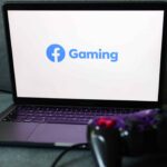 Facebook Gaming logo displayed on a laptop screen and a gamepad are seen in this illustration photo taken in Krakow, Poland on August 23, 2022.