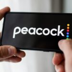 In this photo illustration a Peacock logo seen displayed on a smartphone.