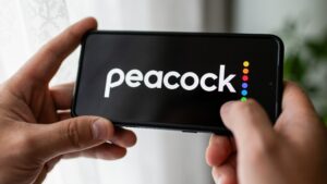 In this photo illustration a Peacock logo seen displayed on a smartphone.