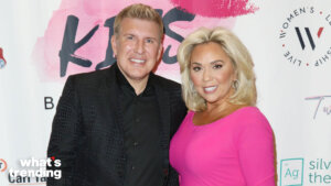 Todd Chrisley and Julie Chrisley posing at a What's Trending event with branded backdrop