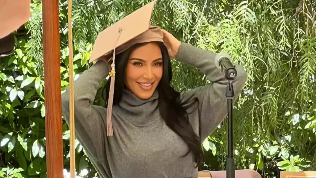 Kim Kardashian putting on her cap at the graduation ceremony. Photo: Simone Harouche/Instagram