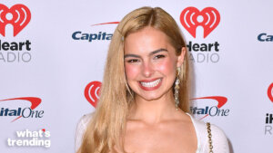 Blonde woman smiling at iHeartRadio event with Capital One logos in background