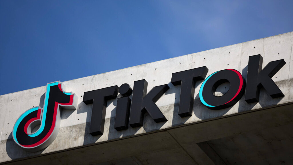 TikTok logo and sign mounted on a concrete building under a clear blue sky
